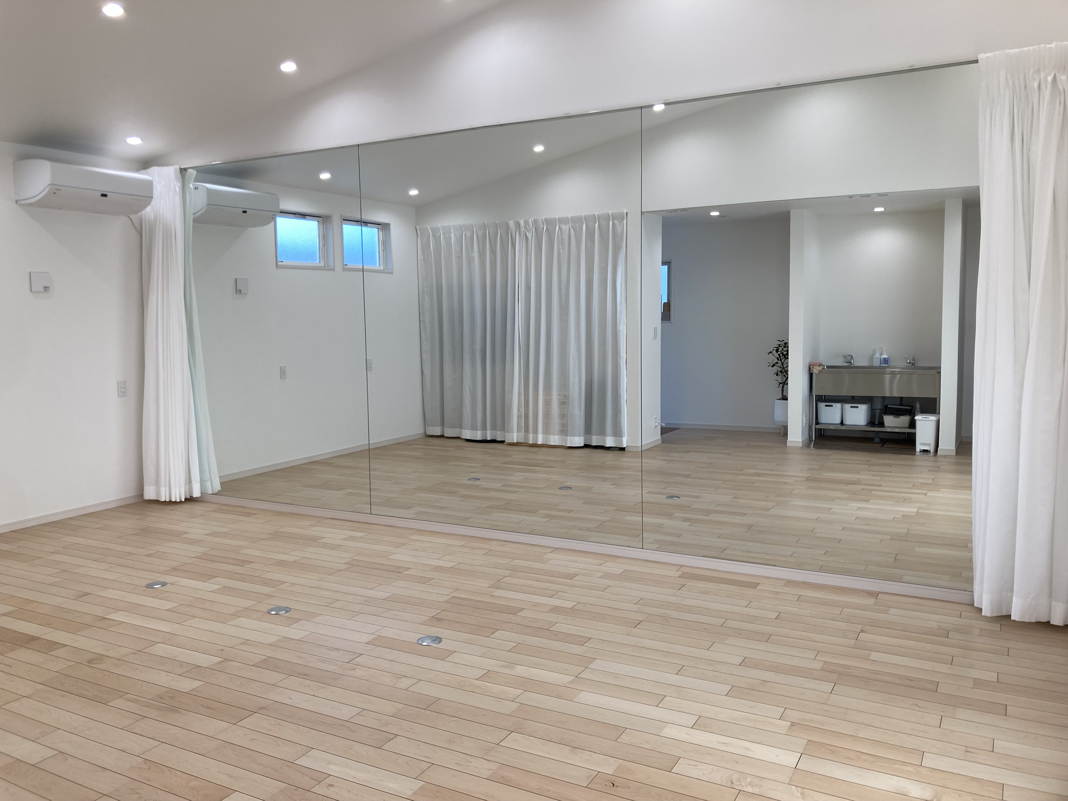 壁一面の大型鏡を備えたスタジオの様子